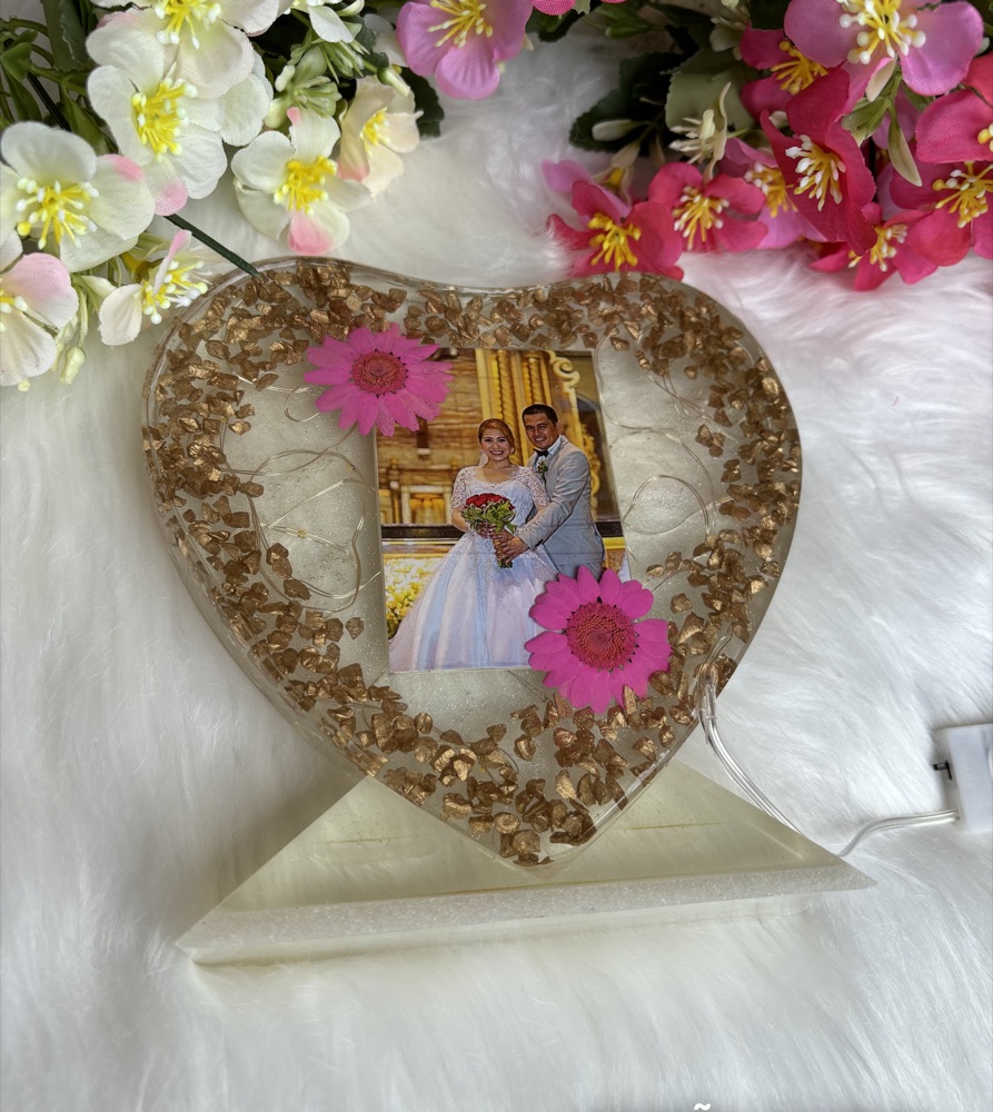 Portarretrato de resina en forma de corazón con flores secas.