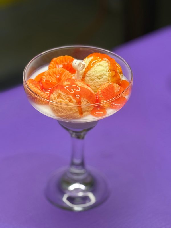 Vela artesanal tipo postre en copa, con efecto de helado y frutas.