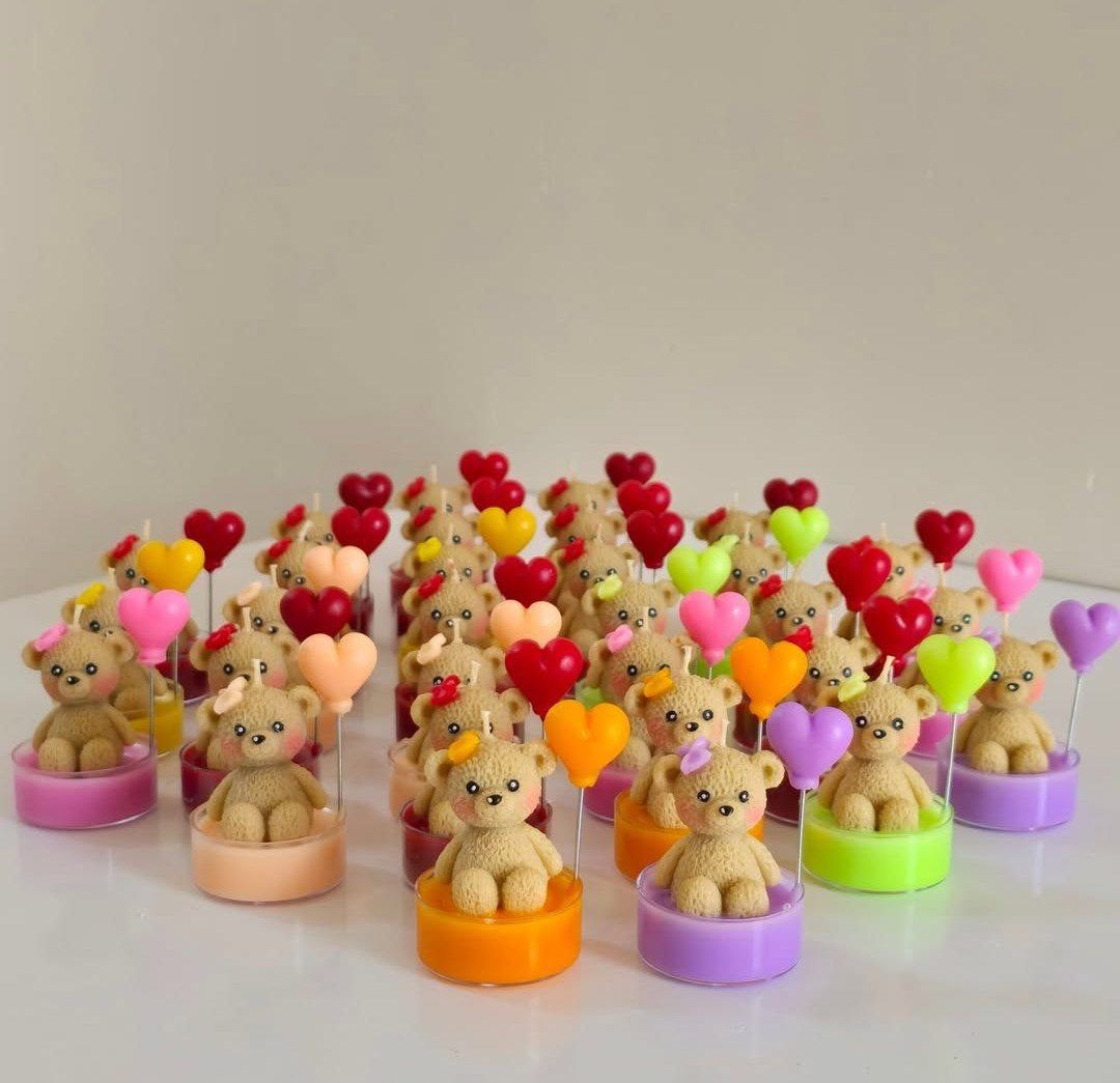 Velas souvenir de ositos de colores con corazones, listas para vender.
